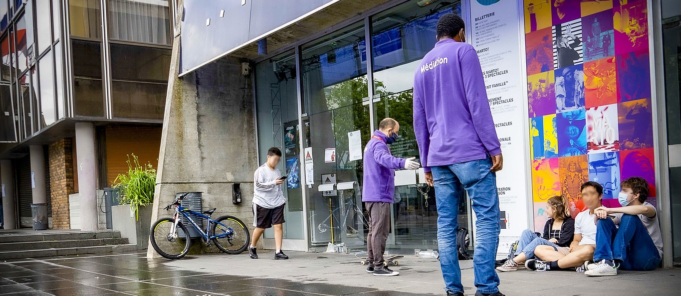 Deux médiateurs Promévil en échange avec des jeunes sur le parvis d'un équipement